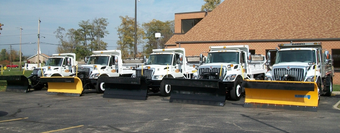 line of trucks with plows on them