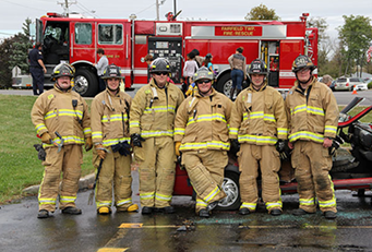 Fire fighters standing in front of a truck